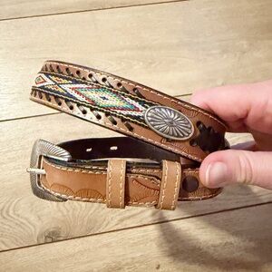 Western-style vintage leather belt with beaded inlay and a concho buckle